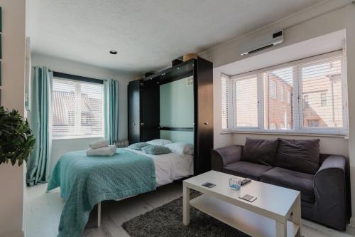 - une petite chambre avec un lit et un canapé dans l'établissement Hullidays - Trinity Studio Apt., à Hull