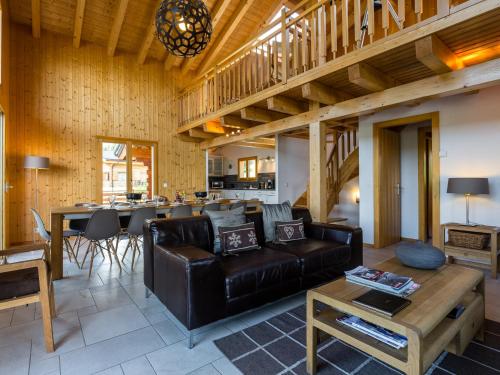 a living room with a leather couch and a table at Chalet le Fauconnier in La Tzoumaz