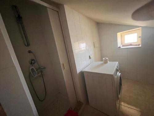 uma casa de banho com um chuveiro e uma máquina de lavar roupa em Casa Anna em Pomarico