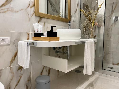 a bathroom with a white sink and a shower at Pompei via Roma Suite in Pompei