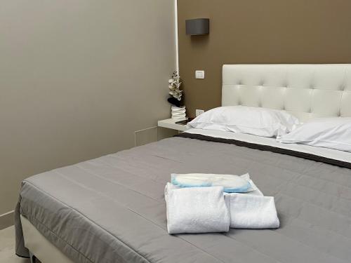a bedroom with a large bed with two towels on it at Pompei via Roma Suite in Pompei