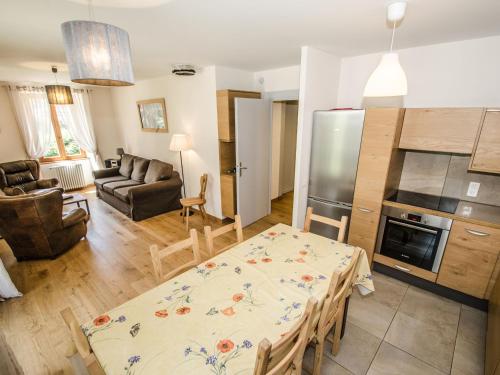 Il dispose d'une cuisine et d'un salon avec une table et un réfrigérateur. dans l'établissement Appartement central à Chamonix proche pistes avec balcon et WiFi - FR-1-343-194, à Chamonix-Mont-Blanc