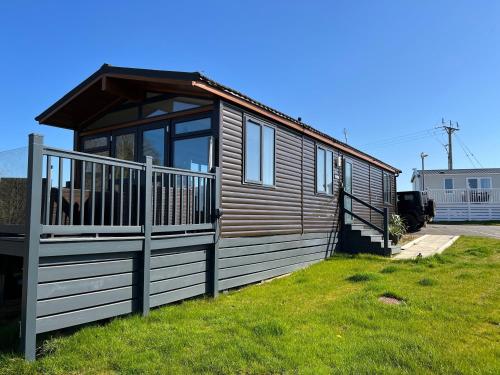 a small cabin with a porch and a deck at Brackenrigg Lodge in Felton