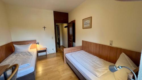 Postel nebo postele na pokoji v ubytování Kloster Steinfeld Gästehaus
