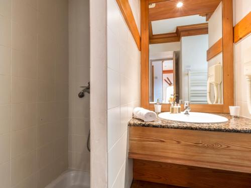 une salle de bain avec un lavabo, une baignoire et un miroir dans l'établissement Studio cosy et lumineux au cœur de Val-d'Isère, proche pistes, commerces, et commodités. - FR-1-694-84, à Val dʼIsère