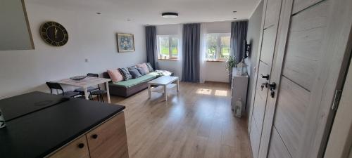 a kitchen and living room with a couch and a table at Apartament Przystań in Frombork