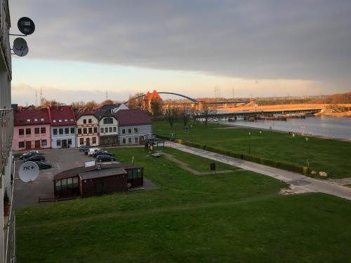 a view of a city with a river and a bridge at Apartament Wolin z Widokiem Na Rzekę Dziwną - Valhalla Apart in Wolin