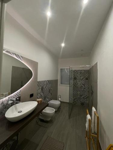 łazienka z 2 toaletami, umywalką i prysznicem w obiekcie Dal Barone Rooms w mieście Salemi