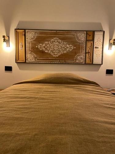 łóżko z dużym drewnianym zagłówkiem w sypialni w obiekcie Dal Barone Rooms w mieście Salemi