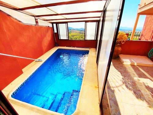 Una pequeña piscina en una habitación con ventana. en Vivienda de estilo rústico con piscina LA GRANÁ, en Bullas