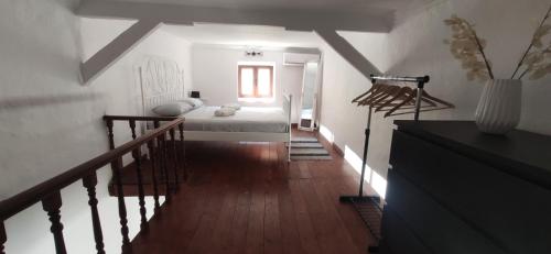 ein weißes Zimmer mit einem Bett und einer Treppe in der Unterkunft Old Town Maisonette in Rhodos (Stadt)