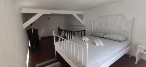 ロードス・タウンにあるOld Town Maisonetteの白いベッド(枕2つ付)が備わる客室です。
