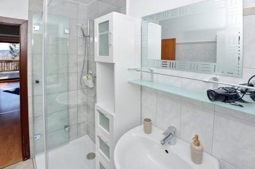 a white bathroom with a sink and a shower at Ferienwohnung Karawankenblick in Bach