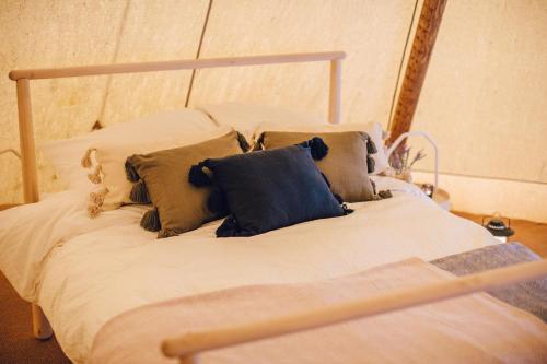 a bed with pillows on it in a room at GreenWood Family Park in Y Felinheli