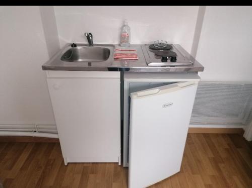 - un comptoir de cuisine avec un évier et 2 placards blancs dans l'établissement Aux Oyats d Isa, à Fort-Mahon-Plage