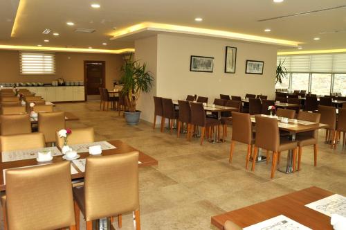 a dining room with tables and chairs in a restaurant at Parwar Hotel in Duhok