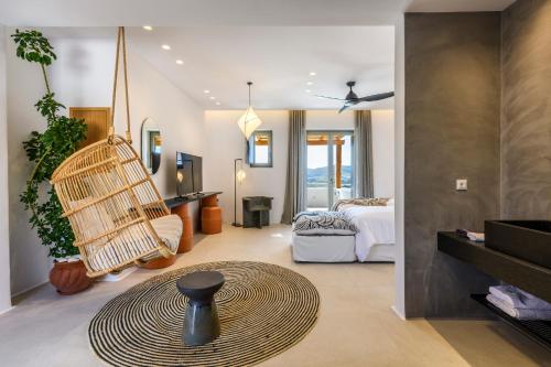 a room with a swinging chair and a bedroom at The Mykonist Panormos Exclusive Suites & Villas in Panormos Mykonos