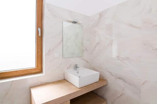 ein weißes Badezimmer mit einem Waschbecken und einem Spiegel in der Unterkunft Villa Shelly whith private pool in Lozenets