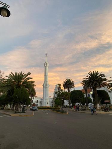 um grande edifício branco com uma torre de relógio à distância em La Negrita Host em Sucre