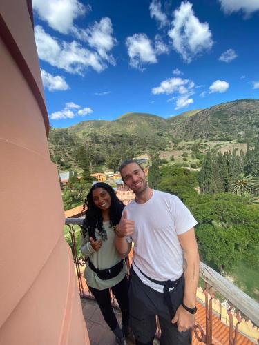 a man and a woman standing on a balcony at La Negrita Host in Sucre