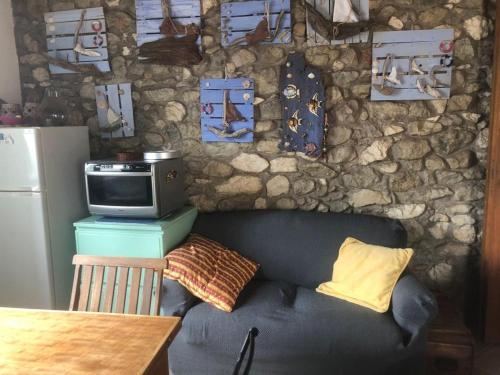 sala de estar con sofá y pared de piedra en Il nido di Agnese en Garda