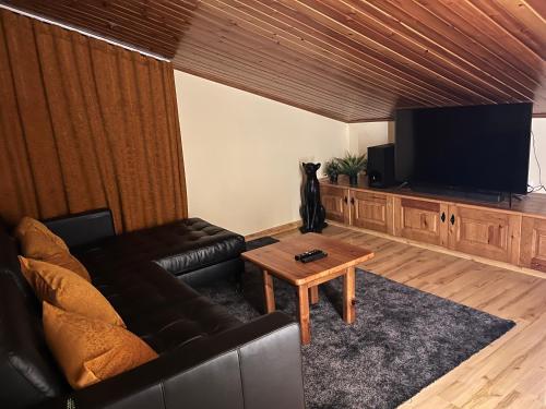 uma sala de estar com um sofá e uma televisão em Hostal Cal Franciscó em Gósol
