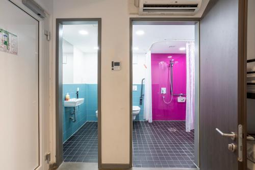 baño con aseo rosa y lavamanos en Jaeger´s Munich (Hotel/Hostel), en Múnich