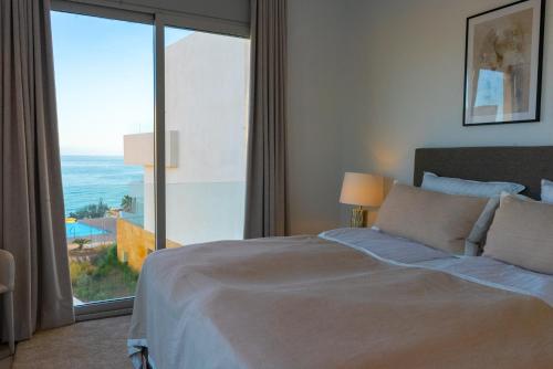 una camera con un letto e una grande finestra di Villa Palm Beach - Incredible villa with 5 rooms, amazing sea view and private pool a Fuengirola