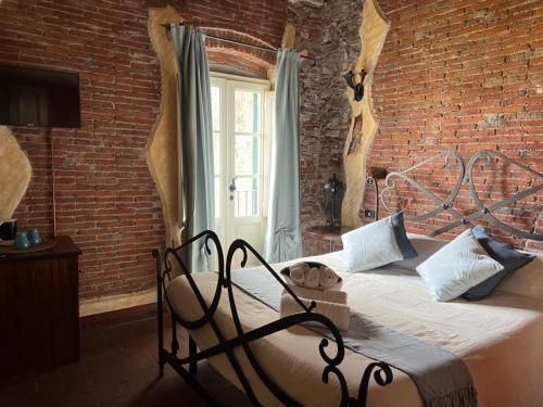 a bedroom with a bed in a brick wall at Corte Dei Folletti in Lucca