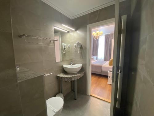 a bathroom with a sink and a toilet and a mirror at Pensiunea Korona in Miercurea-Ciuc