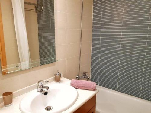 ein Badezimmer mit einem Waschbecken, einem Spiegel und einer Badewanne in der Unterkunft Maravilloso piso con piscina a 200m de la playa in Lloret de Mar