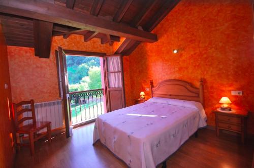 a bedroom with a large bed and a large window at Casa de Aldea La Redondiella in Berodia