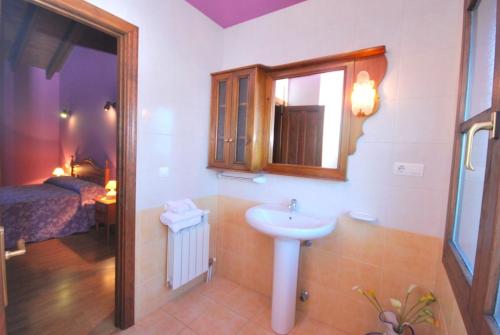 baño con lavabo, espejo y cama en Casa de Aldea La Redondiella, en Berodia