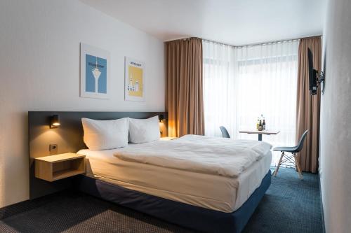 een hotelkamer met een groot bed en een bureau bij Apartments an der Kö in Düsseldorf