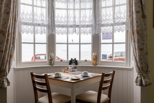a table and two chairs in front of a window at Seaspray Guest House in Weymouth