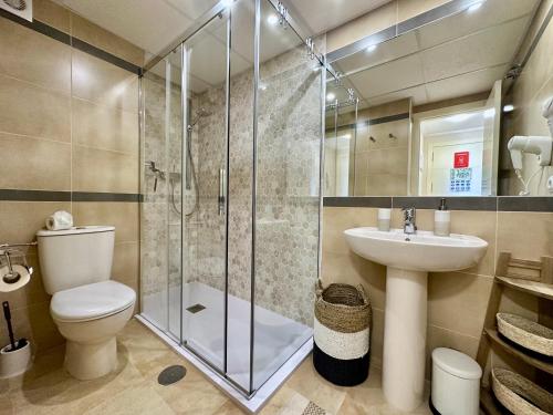 een badkamer met een douche, een toilet en een wastafel bij Esmeralda Suites 21º piso in Calpe