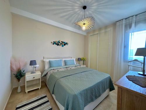 a bedroom with a bed and a chandelier at Esmeralda Suites 21º piso in Calpe