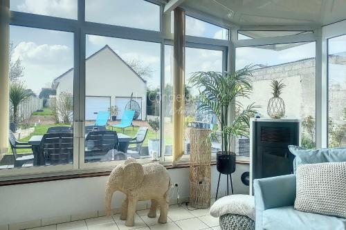 uma sala de estar com vista para um pátio através de uma janela em FM42 - À Ciel Ouvert Maison avec grande veranda et jardin em Friaucourt