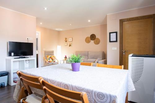 a dining room with a white table and chairs at Apartamento Cangas Relax in Cangas de Onís