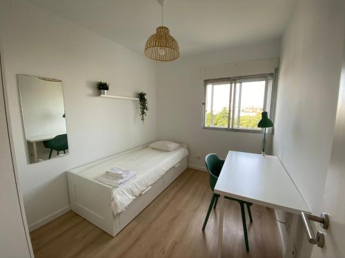 Habitación con cama, mesa y ventana en Carcavelos Beach walking distance room in shared apartment en Oeiras