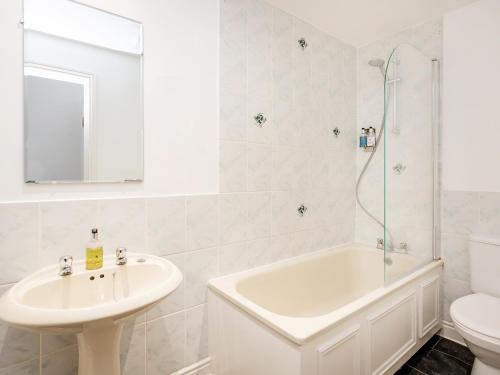 a white bathroom with a sink and a tub and a toilet at The Washington in Bristol