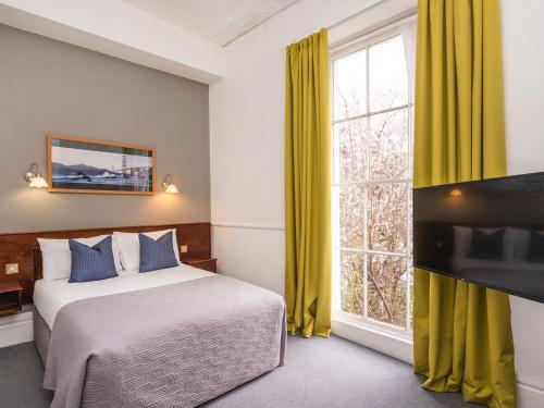 a bedroom with a bed and a large window at The Washington in Bristol