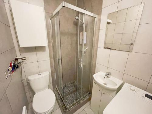uma casa de banho com um chuveiro, um WC e um lavatório. em Cozy studio apartment Yellow in Gdansk Wrzeszcz em Gdansk