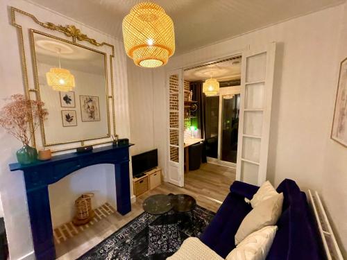 a living room with a blue fireplace and a mirror at Escale bohème - Terrasse en centre-ville - Gare in Amiens