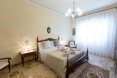 a bedroom with a bed and a chair and a window at Casa Vacanze Kennedy in Favara