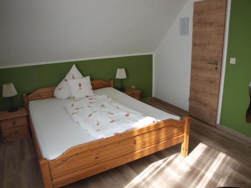 a bedroom with a wooden bed with green walls at Landgasthof Zum goldenen Löwen in Moosbach
