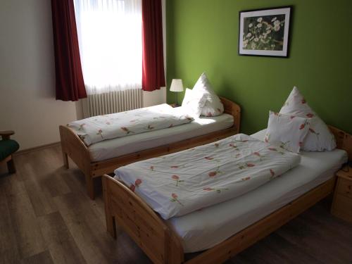 two beds in a room with green walls at Landgasthof Zum goldenen Löwen in Moosbach