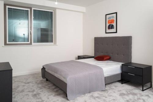 a bedroom with a large bed and a window at Luxury Free Parking Townhouse in Manchester