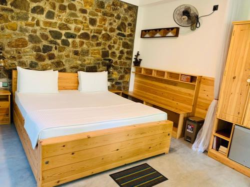 ein Schlafzimmer mit einem Bett und einer Steinmauer in der Unterkunft The Symbol of Ella in Ella