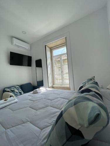 a bedroom with a large bed and a window at Centro da Vila in Ponte de Lima
